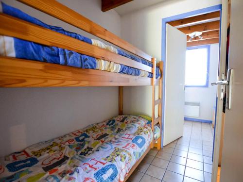 une chambre avec deux lits superposés et une salle de bain dans l'établissement Maison au bord d'un lac avec terrasse, proche commerces et plage - 6 personnes - FR-1-705-56, aux Mathes