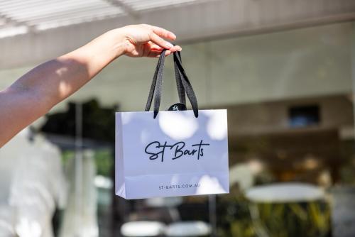 a hand holding a shopping bag with the word selfish at Sage Hotel James Street in Brisbane