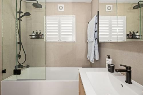 ein Badezimmer mit Waschbecken und Dusche in der Unterkunft Coastal Corner - Contemporary Chic by the Beach in Sydney