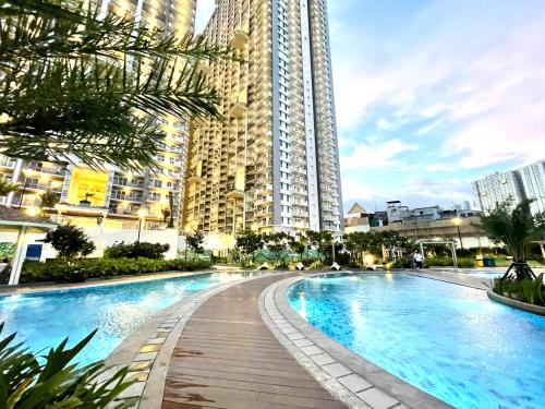 a swimming pool in front of a tall building at mushROOM Condotel at Prisma Residences, Pasig City in Manila