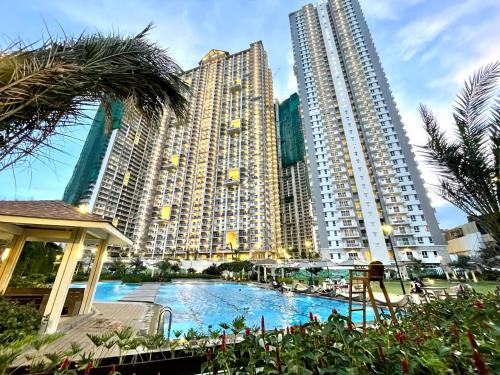 a large apartment complex with a large pool in front of two tall buildings at mushROOM Condotel at Prisma Residences, Pasig City in Manila