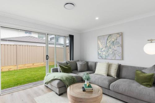 a living room with a couch and a table at South Beach Escape - Sensational Shell Cove Living in Shellharbour