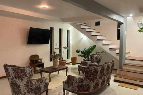 sala de estar con sillas y escalera en Apu House, Privacidad y paz para disfrutar en pareja, familia o amigos, con aire acondicionado, en Turrúcares