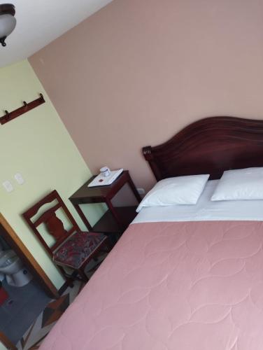 1 dormitorio con 1 cama y 1 mesa con lámpara en Hotel Torre Bolívar, en Pasto