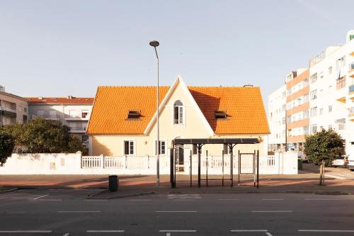 a bus stop in front of a building at Casa Amarela, 9-room beach house in Praia da Barra