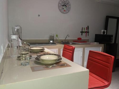 a kitchen with a table with red chairs and a counter top at Pequeño y acojedor departamento muy bien ubicado in Veracruz