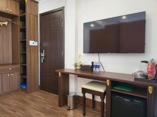 a room with a desk with a television on a wall at RUBY HOTEL Vĩnh Long in Vĩnh Long