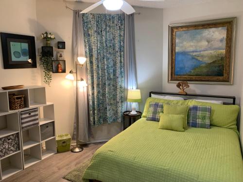 sypialnia z zielonym łóżkiem i oknem w obiekcie IC 215 Treetop Villa w mieście New Braunfels