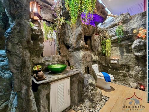 a bathroom in a cave with a rock wall at Arawan Pool Villa Hua Hin in Hua Hin
