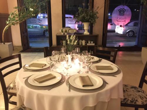 a table with a white table cloth and plates and glasses at Palace Hotel Campos dos Goytacazes in Campos dos Goytacazes