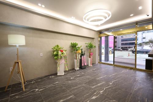 a lobby with a row of vases with flowers in it at Calm Rest Hotel Gimhae in Gimhae