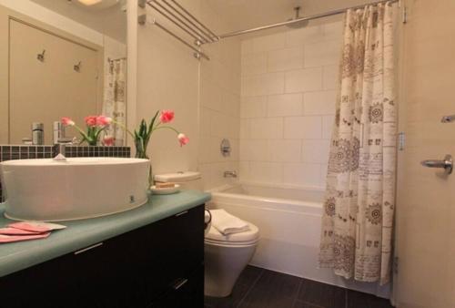 een badkamer met een wastafel, een bad en een toilet bij The Hollywood North Suite in Victoria