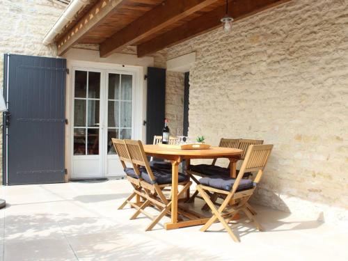 une table et des chaises en bois sur une terrasse dans l'établissement Maison Rénovée 2024 à 2 Pas de la Plage – 8 Couchages, Wifi, Terrasse, Proche Pistes Cyclables - FR-1-246A-283, à Dolus-d'Oléron