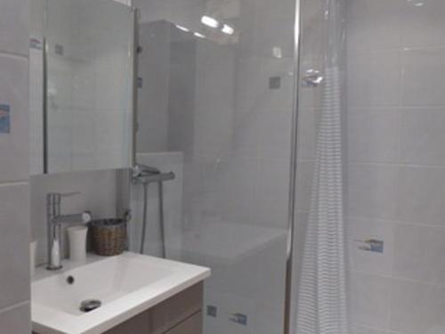une salle de bain blanche avec une douche et un lavabo dans l'établissement Appartement Climatisé 2 Pièces avec Piscine, Tennis et Parking à 500m de la Plage - FR-1-776-73, à Argelès-sur-Mer