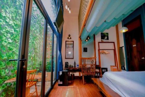 a bedroom with a bed and a large window at Victory Hotel in Hue