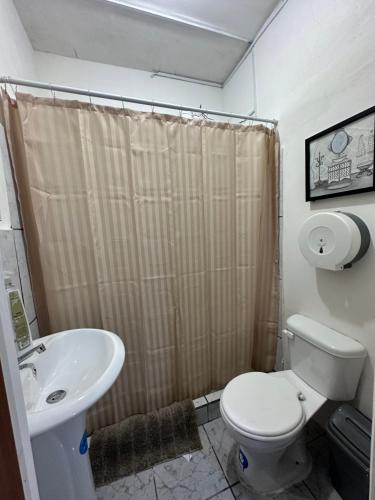 a bathroom with a toilet and a sink at Casa Alicia Hostal Antigua Guatemala in Antigua Guatemala