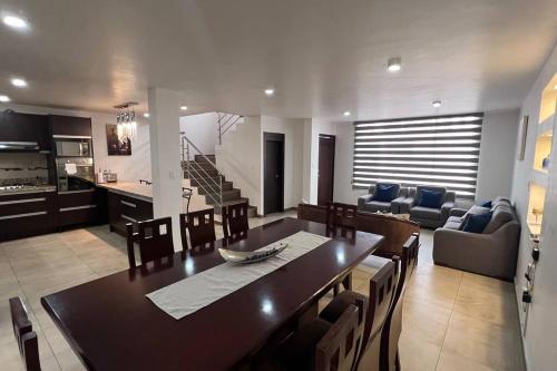 a dining room and living room with a table and chairs at Home Ibarra Parque Ciudad Blanca in Ibarra