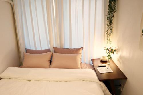 1 dormitorio con 2 camas, mesa y ventana en 3rooms 4beds kitchen Hongik Stn 3min en Seúl