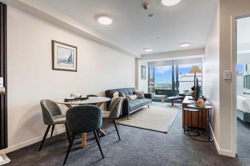a living room with a couch and a table at Zodiak Stays Cozy CBD 2BR Near Top Dining Spots in Auckland
