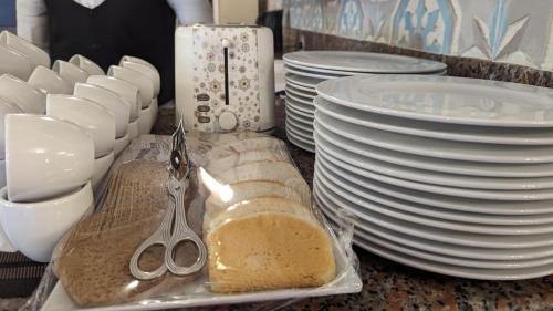 a counter with white plates and a pair of scissors at Eileen Hotel Cairo in Cairo