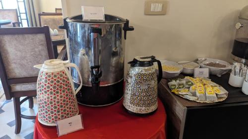 a counter with two coffee makers on a table with food at Eileen Hotel Cairo in Cairo