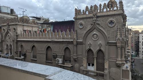 an old building with a clock on the side of it at Eileen Hotel Cairo in Cairo