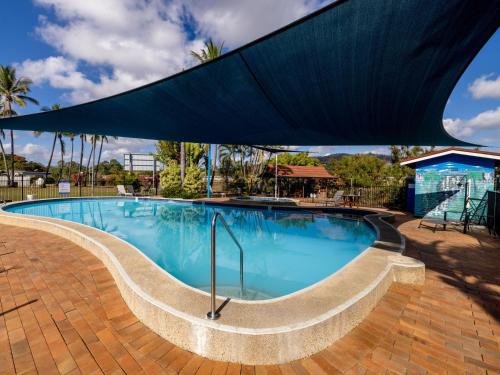 a large blue swimming pool with a blue umbrella at BIG4 Townsville Gateway Holiday Park in Townsville
