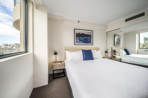 a bedroom with two beds and a window at Oaks Sydney Castlereagh Suites in Sydney