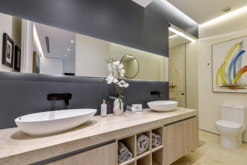 a bathroom with two sinks and a toilet at BEST Views of PV-Banderas Bay from Rooftop Infinity Pool in Puerto Vallarta