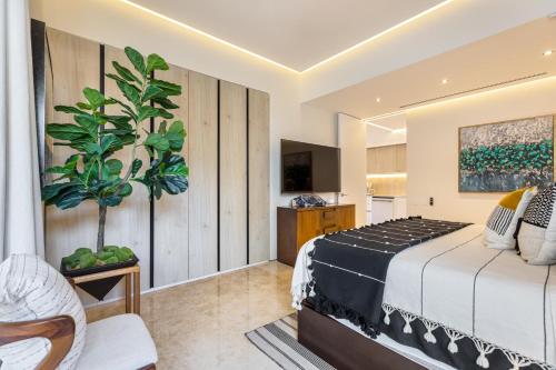 a bedroom with a bed and a plant at BEST Views of PV-Banderas Bay from Rooftop Infinity Pool in Puerto Vallarta