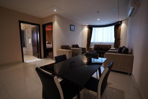a living room with a dining room table and chairs at Ertiaad Tabuk for Hotel Apartment in Tabuk