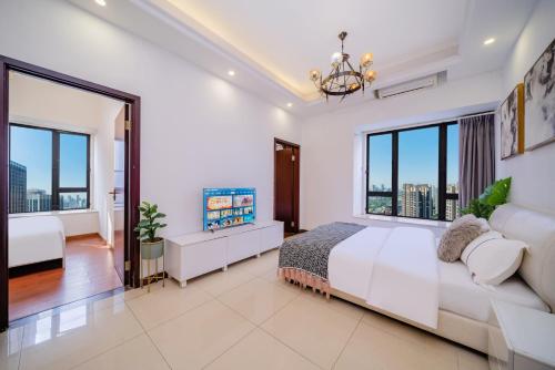 a white bedroom with a large bed and large windows at Oda Theme Apartment (Guangzhou Wanshengwei Pazhou Convention and Exhibition Center) in Guangzhou