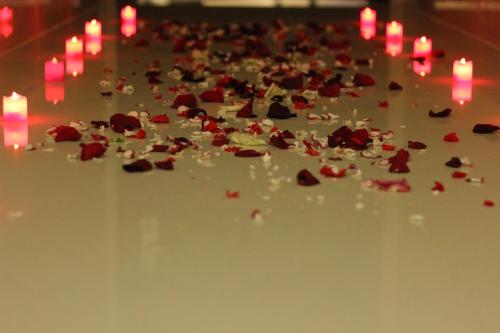 a pile of roses and candles on a table with lights at Ertiaad Tabuk for Hotel Apartment in Tabuk