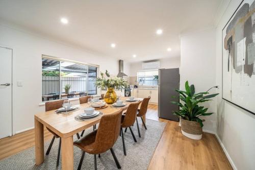 a dining room with a wooden table and chairs at Ambrosia - Designer 3BR WiFi in Norwood