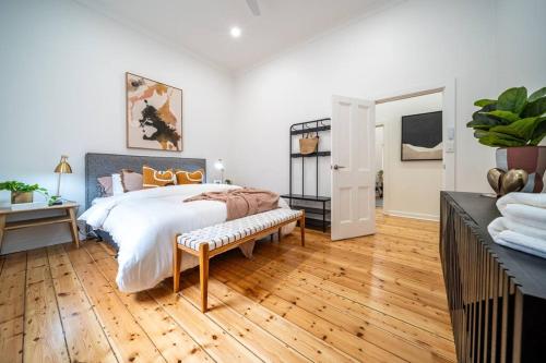 1 dormitorio con 1 cama grande y suelo de madera en Ambrosia - Designer 3BR WiFi en Kensington and Norwood