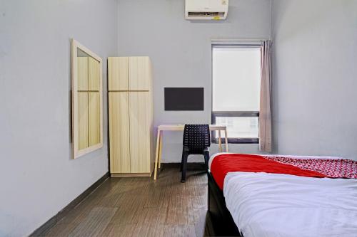 a bedroom with a bed and a desk and a table at OYO 93328 Graha Citra Syariah in Karajaan