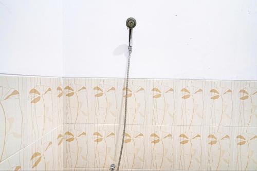 a shower curtain with a shower head in a bathroom at OYO 93328 Graha Citra Syariah in Karajaan
