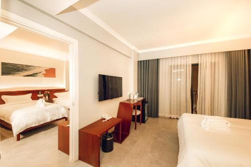 a hotel room with two beds and a television at Solar Hotel in Siem Reap