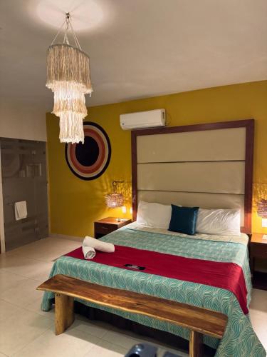 a bedroom with a bed and a chandelier at Suites Valentina in Puerto Morelos