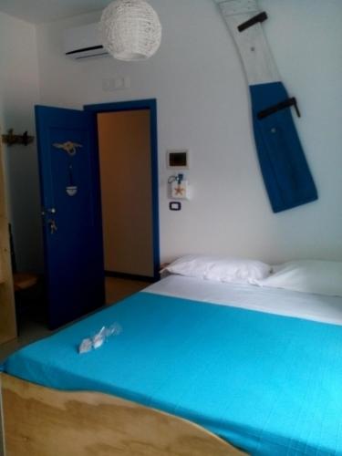 a bedroom with a blue bed and a blue door at ControVento Rooms in Margherita di Savoia