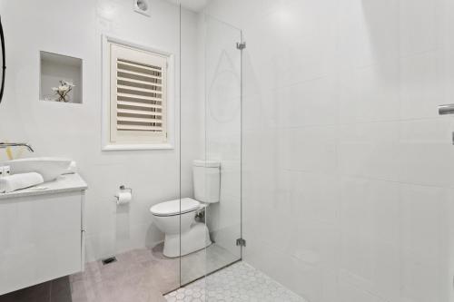 ein weißes Bad mit einem WC und einem Waschbecken in der Unterkunft Comfy 2-Bed Apartment with AC throughout in Sydney