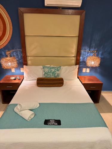 a bedroom with a bed with two night stands at Suites Valentina in Puerto Morelos
