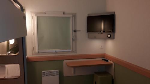 a small bathroom with a sink and a window at Ibis Budget St Gratien - Enghien-Les-Bains in Saint-Gratien
