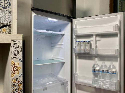 an open refrigerator with bottles of water in it at Casa Iktal Luxury - Centro Mérida in Mérida