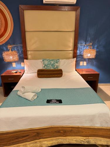 a bedroom with a bed with two towels and two lamps at Suites Valentina in Puerto Morelos
