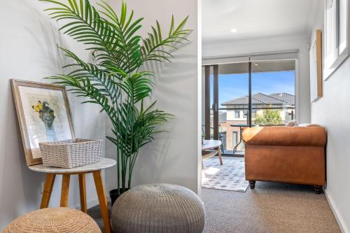 ein Wohnzimmer mit einem Stuhl und einer Pflanze in der Unterkunft Point Cook's Spacious and Comfy 4BR/3BA Haven! in Point Cook