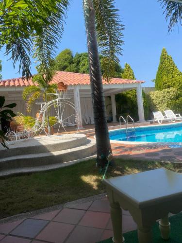 a house with a swimming pool and a table at Valle Suites, la Mejor Ubicación in Valledupar