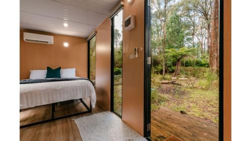 1 dormitorio con 1 cama y puerta corredera de cristal en Quantum Field en Toolangi