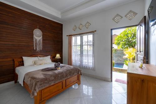 a bedroom with a bed and a large window at Widia Homestay Nusa Lembongan in Nusa Lembongan