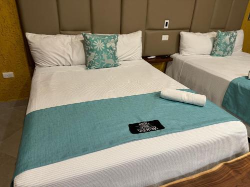 a hotel room with two beds with towels on them at Suites Valentina in Puerto Morelos